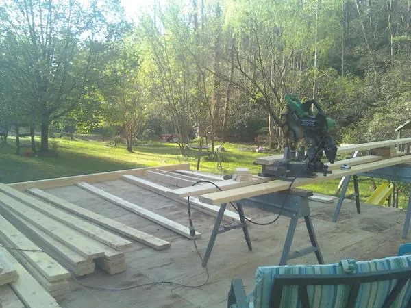 Miter saw and framing lumber on a deck under construction in Clarksburg