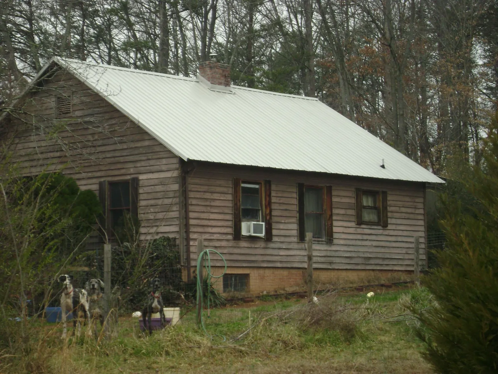 White metal roof on an old wood sided farmhouse, from a Metal Roof Installation job in Clarksburg